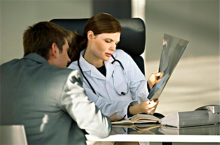 doctor looking at xray - Female doctor showing an X-Ray report to a patient Stock Photo - Premium Royalty-Free, Code: 6108-05860310
