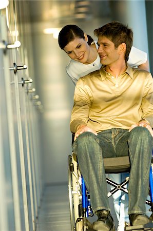 doctors walking in hallway - Female doctor pushing a male patient sitting in a wheelchair Stock Photo - Premium Royalty-Free, Code: 6108-05860445