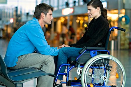 female wheelchair woman - Side profile of a mid adult man talking with a young woman Stock Photo - Premium Royalty-Free, Code: 6108-05860452