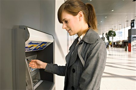Side profile of a businesswoman using an ATM Foto de stock - Sin royalties Premium, Código: 6108-05860588