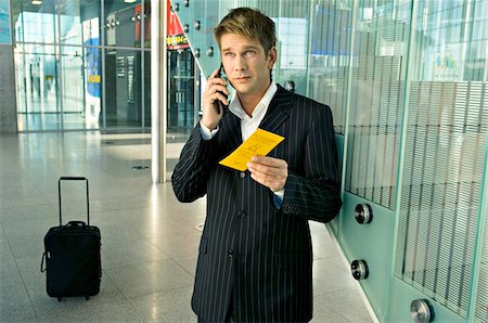 simsearch:6108-05860566,k - Businessman holding an airplane ticket and talking on a mobile phone Stock Photo - Premium Royalty-Free, Code: 6108-05860523