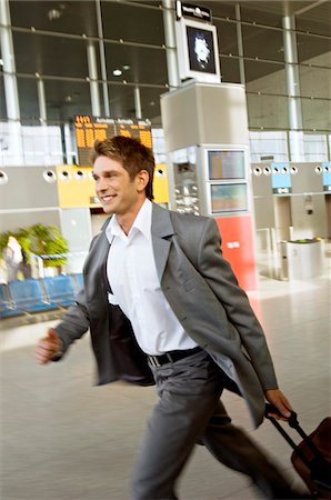 se dépêcher - Profil de côté d'un homme d'affaires se précipiter avec ses bagages dans un aéroport Photographie de stock - Premium Libres de Droits, Code: 6108-05860527