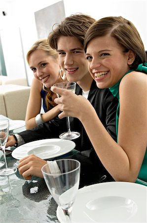 simsearch:6108-05858214,k - Two young women with a teenage boy at a dinner party Stock Photo - Premium Royalty-Free, Code: 6108-05860646