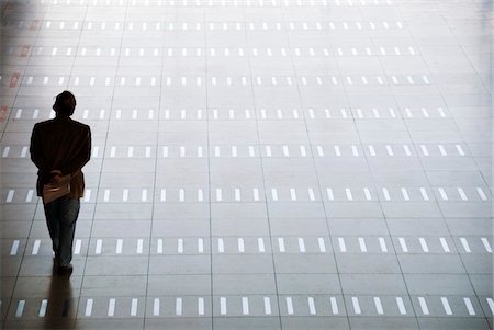 silhouette man not illustration not white background not cutout not couple not friends not family not black background - Man walking at airport, rear view Stock Photo - Premium Royalty-Free, Code: 6108-05860602