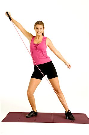 simsearch:6108-05857454,k - Portrait of a young woman exercising with a resistance band Stock Photo - Premium Royalty-Free, Code: 6108-05860877