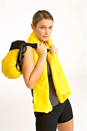 Portrait of a female boxer carrying boxing gloves on her shoulder Stock Photo - Premium Royalty-Free, Code: 6108-05860895