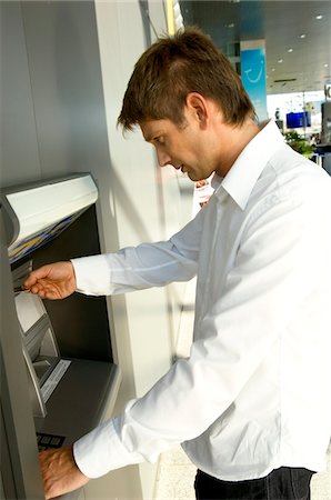 person at vending machine - Side profile of a businessman using an ATM Stock Photo - Premium Royalty-Free, Code: 6108-05860800