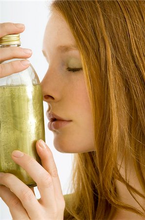 simsearch:6108-05861350,k - Close-up of a young woman smelling a bottle of aromatherapy oil Fotografie stock - Premium Royalty-Free, Codice: 6108-05860975