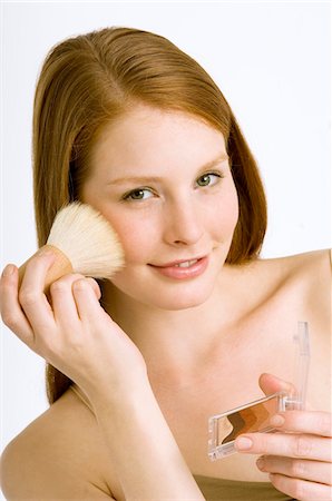 Portrait d'une jeune femme, appliquer le fard à joues sur sa joue Photographie de stock - Premium Libres de Droits, Code: 6108-05860991