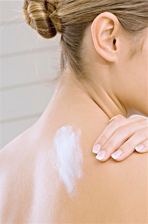 shoulder (anatomy) - Rear view of a young woman applying moisturizer on her shoulder Foto de stock - Sin royalties Premium, Código: 6108-05860920