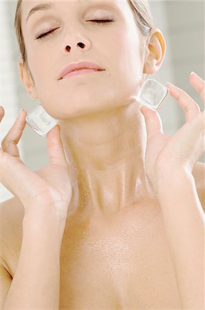 selfish - Close-up of a young woman rubbing ice cubes on her neck Stock Photo - Premium Royalty-Free, Code: 6108-05860924