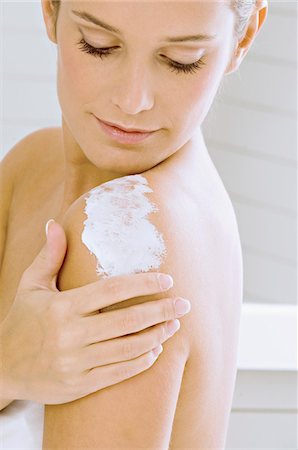 spalmare (applicare) - Side profile of a young woman applying moisturizer on her shoulder Fotografie stock - Premium Royalty-Free, Codice: 6108-05860930