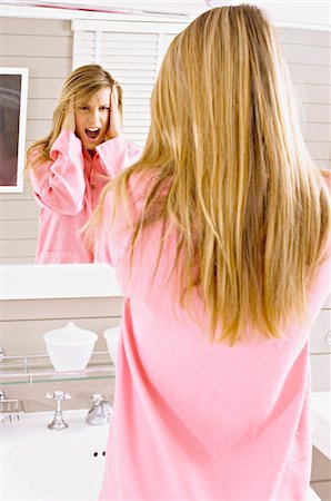 Reflet d'une jeune femme regardant dans le miroir et en criant Photographie de stock - Premium Libres de Droits, Code: 6108-05860931