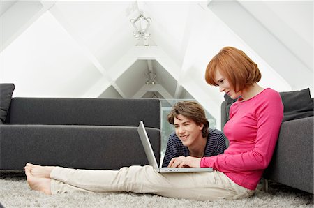 Side profile of a young woman and a teenage boy using a laptop Stock Photo - Premium Royalty-Free, Code: 6108-05861049