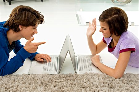 Side profile of a young woman and a teenage boy using laptops Stock Photo - Premium Royalty-Free, Code: 6108-05861061