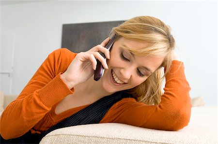Close-up of a young woman talking on a mobile phone and smiling Stock Photo - Premium Royalty-Free, Code: 6108-05861068