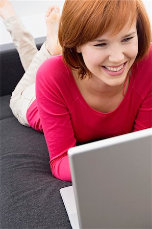 simsearch:6108-05861100,k - Young woman using a laptop and smiling Fotografie stock - Premium Royalty-Free, Codice: 6108-05861081