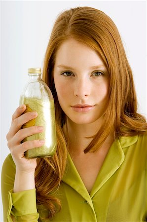Portrait of a young woman holding a bottle of aromatherapy oil Stock Photo - Premium Royalty-Free, Code: 6108-05861013
