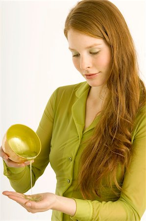 essential oils - Jeune femme verser de l'huile de massage sur sa paume Photographie de stock - Premium Libres de Droits, Code: 6108-05861010