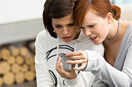 sad woman with short hair - Two young women looking into a change purse Stock Photo - Premium Royalty-Free, Code: 6108-05861152