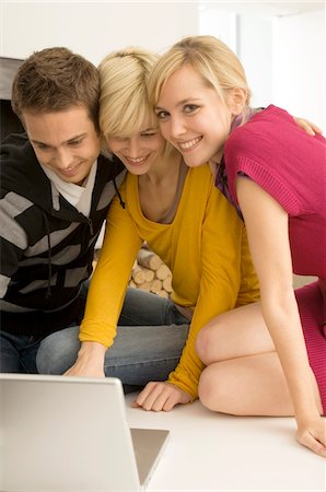 simsearch:6108-05860085,k - Two young women and a young man using a laptop and smiling Foto de stock - Royalty Free Premium, Número: 6108-05861102