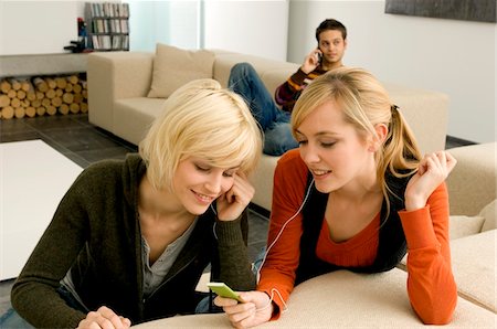 simsearch:6108-05861100,k - Two young women listening to an MP3 player Fotografie stock - Premium Royalty-Free, Codice: 6108-05861132