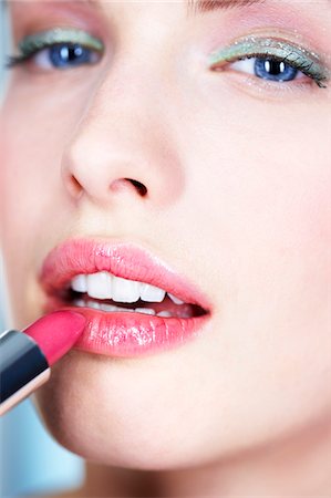 simsearch:6108-05857396,k - Portrait of young woman applying lipstick Stock Photo - Premium Royalty-Free, Code: 6108-05861244