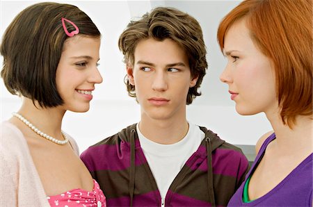 Close-up of a teenage boy with two young women Stock Photo - Premium Royalty-Free, Code: 6108-05861211