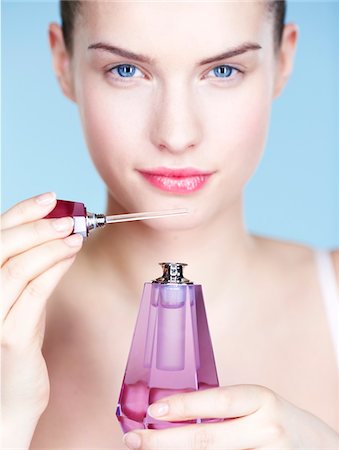 perfume bottle on white - Young woman smelling perfume Stock Photo - Premium Royalty-Free, Code: 6108-05861349