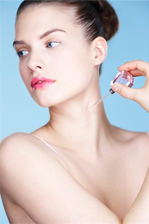 Young woman applying perfume Stock Photo - Premium Royalty-Free, Code: 6108-05861302