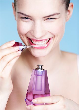 perfume bottle on white - Young woman smelling perfume Stock Photo - Premium Royalty-Free, Code: 6108-05861326