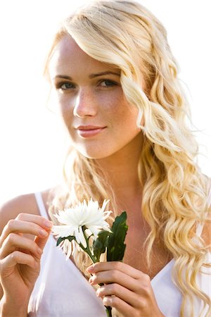 Young woman holding a white flower Stock Photo - Premium Royalty-Free, Code: 6108-05861469