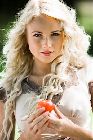 summer eating and clothes - Young woman holding a tomato Stock Photo - Premium Royalty-Free, Code: 6108-05861411