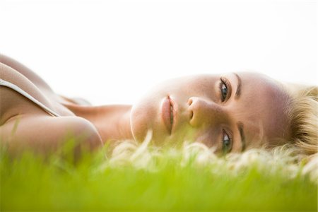 Young woman lying in the grass Stock Photo - Premium Royalty-Free, Code: 6108-05861422
