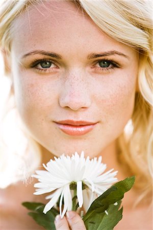 Portrait of a young woman holding a white flower Stock Photo - Premium Royalty-Free, Code: 6108-05861551