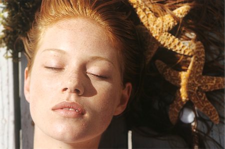 eye and bronze - Young woman lying outdoors, sunbathing Stock Photo - Premium Royalty-Free, Code: 6108-05861598