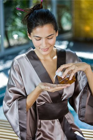 Woman pouring oil on her hand from a dispenser Stock Photo - Premium Royalty-Free, Code: 6108-05861658