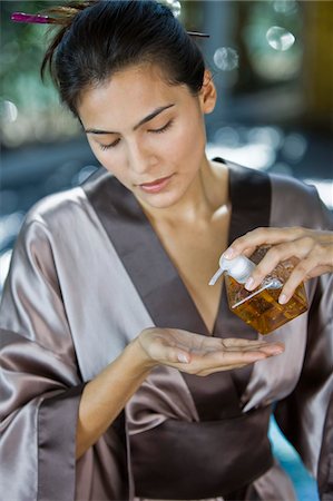 Woman pouring oil on her hand from a dispenser Stock Photo - Premium Royalty-Free, Code: 6108-05861677