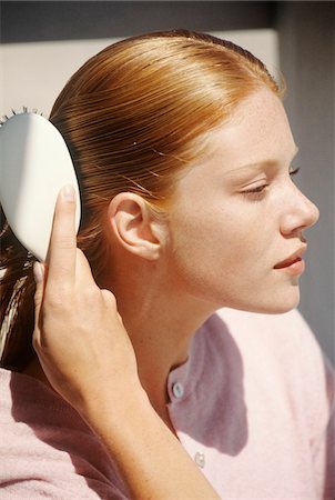 shiny - Young woman brushing her hair, outdoors Stock Photo - Premium Royalty-Free, Code: 6108-05861605