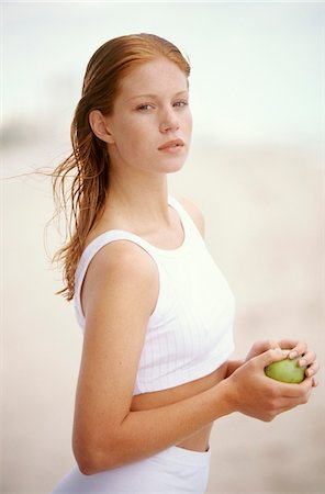 shorts female redhead - Young woman holding an apple, outdoors Stock Photo - Premium Royalty-Free, Code: 6108-05861613