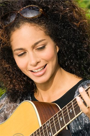 simsearch:6108-05863620,k - Woman playing a guitar and smiling Foto de stock - Sin royalties Premium, Código: 6108-05861786