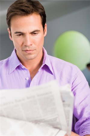 Close-up of a man reading a newspaper Stock Photo - Premium Royalty-Free, Code: 6108-05861874