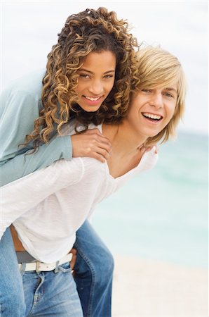 Girl riding piggyback on a teenage boy on the beach Foto de stock - Sin royalties Premium, Código: 6108-05862006