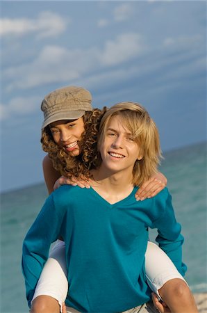 Girl riding piggyback on a teenage boy on the beach Stock Photo - Premium Royalty-Free, Code: 6108-05862031