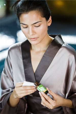 Woman holding a bottle of aromatherapy oil Stock Photo - Premium Royalty-Free, Code: 6108-05862237