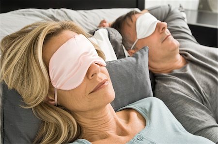 simsearch:6108-05863892,k - Couple dormir dans son lit, portant des masques pour les yeux Photographie de stock - Premium Libres de Droits, Code: 6108-05862238