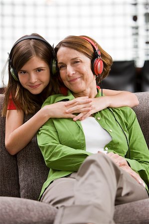 simsearch:6108-05858176,k - Woman listening to music and her granddaughter hugging from behind Stock Photo - Premium Royalty-Free, Code: 6108-05862365