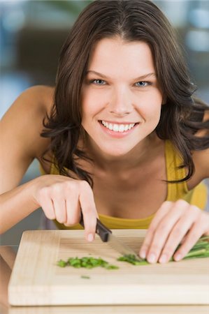 person cutting food on cutting boards - Woman chopping chives Stock Photo - Premium Royalty-Free, Code: 6108-05862442