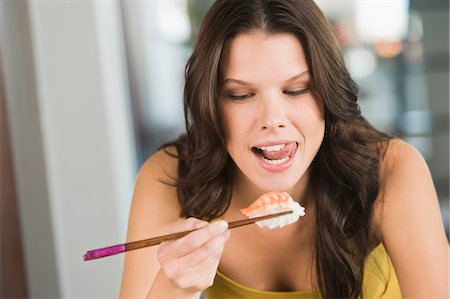 Close-up of a woman eating sushi Foto de stock - Sin royalties Premium, Código: 6108-05862425