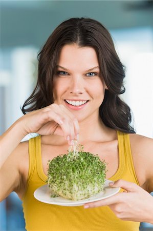 Woman eating bean sprouts and smiling Foto de stock - Sin royalties Premium, Código: 6108-05862439